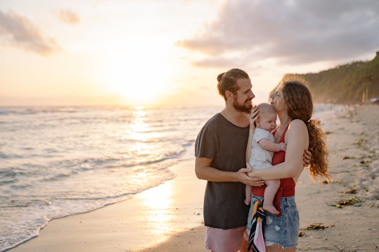 man and Woman Holding a Baby on Beach